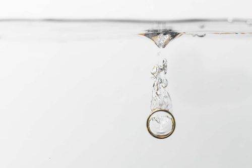 View of a wedding ring dropped in water. Concept for What to Do With Your Wedding Ring After Divorce.
