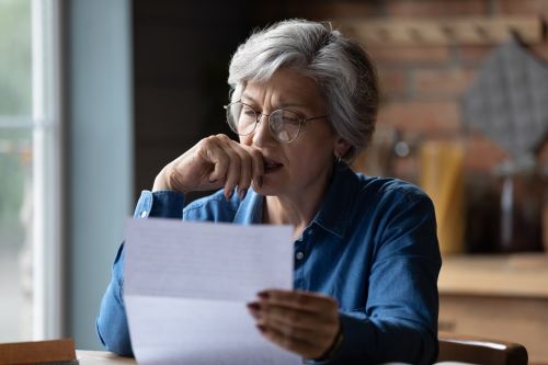 Hispanic female reading over documents at home office concept for First-Time Executors of an Estate.