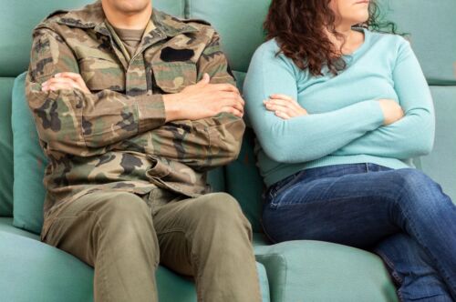 Cropped shot of a soldier and his unrecognizable wife sitting on the couch with their arms crossed Visual concept for a blog discussing Military Divorce.