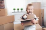 Cute little boy helping out packing boxes and moving. Visual concept for a family law blog discussing issues divorced parents face when moving out of state with a child.